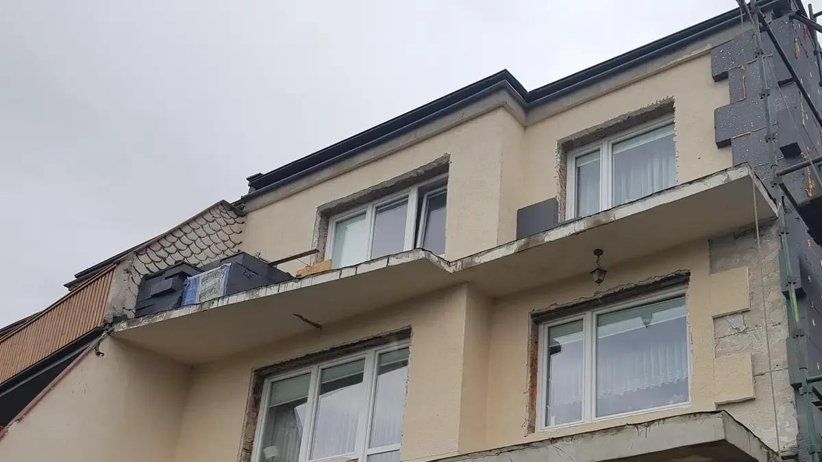 Piętrowy dom w trakcie ocieplania ścian, z przygotowanymi ościeżami okien i płytami izolacji na narożniku